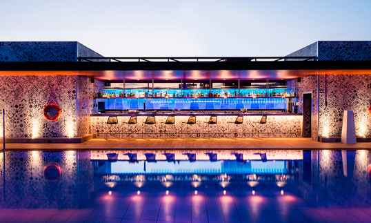 El espectacular juego de luces que logran los cristales Lightinglass en la contra-barra del bar de la piscina.