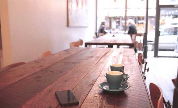 Tazas de café y móvil en una cafetería