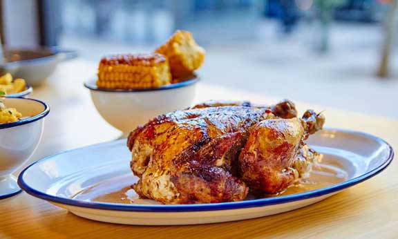 El pollo macerado y asado lentamente al carbón es la estrella de Le Coq