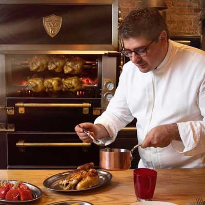 Profesionalhoreca. el chef Eugeni de Diego preparando pollos asados en Apluma