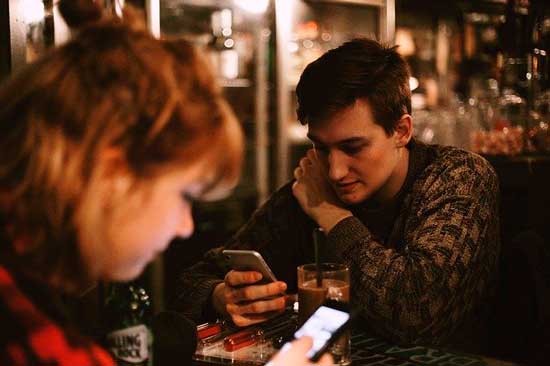 Profesionalhoreca, pareja con el móvil en un bar