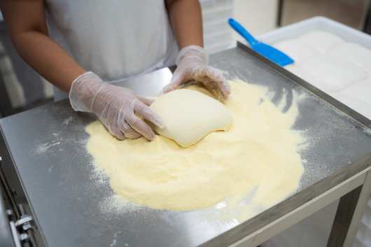 Profesional Horeca, trabajando manualmente la masa de pizza en The DoughLAB