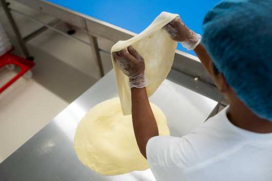 Profesional Horeca, estirando manualmente la masa de pizza en The DoughLAB