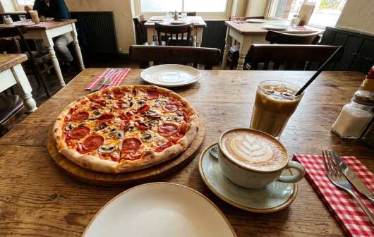 Profesional Horeca, pizza y café en la mesa de un restaurante