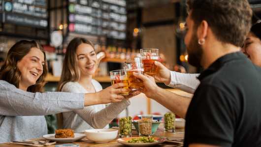 Profesional Horeca, jóvenes brindando con cerveza en un bar